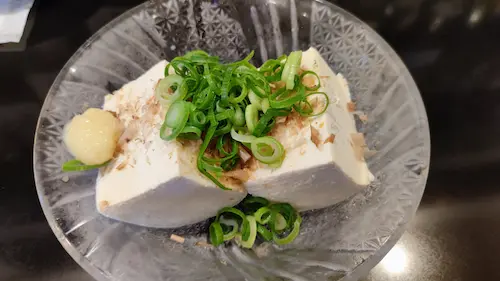 冷やした豆腐に刻みネギと生姜を添えた冷ややっこ。シンプルでさっぱりした定番の一品